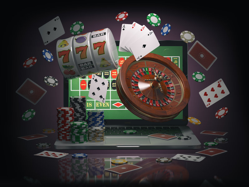 Online casino concept. Laptop with roulette, slot machine, casino chips and playing cards isolated on black background., août 2021